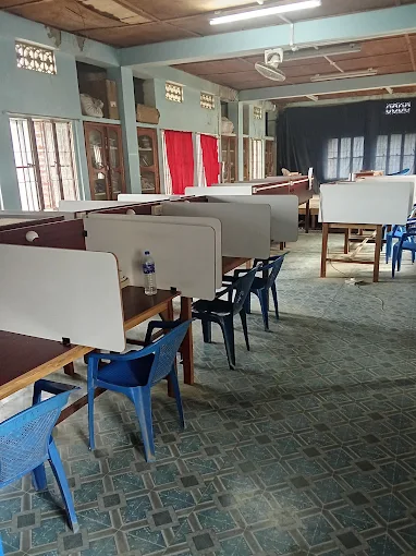 Reading hall with rows of individual study carrels, chairs, and glass-fronted book cabinets.